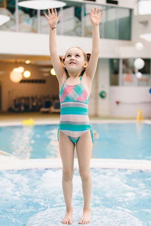 Little girl standing in pool